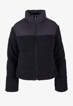 Juodas užtrauktukas švarkas, turintis tekstūruotą fliso kūną ir lygų viršutinį skyrių. Aukštas apykaklė ir dvi priekinės kišenės. Ilgos rankovės.