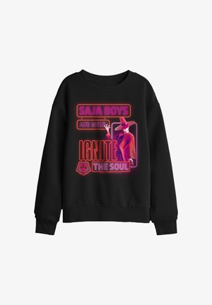 Black sweatshirt with neon pink and red text "SAJA BOYS," Korean characters, "IGNITE THE SOUL," a lion logo, and a figure wearing a large hat.