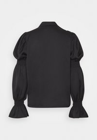 Blouse noire à texture lisse, dotée d'un col avec revers et de manches volumineuses bouffantes avec poignets froncés. Design simple et élégant.