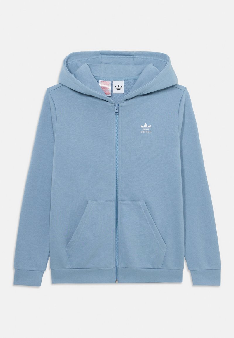 Haut de sweat à capuche zippé bleu clair en tissu doux. Il présente une poche kangourou, des poignets côtelés et un petit logo Adidas blanc sur la poitrine.