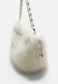 Hvid faux fur håndtaske med en kraftig sølvfarvet kædetræk og lynlåsdetaljer. Rundet form med blød, fluffy tekstur.