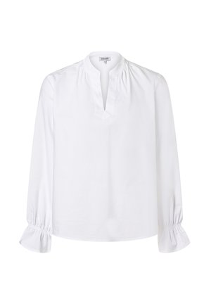 Blouse blanche à manches longues en coton léger. Présente un plastron partiel, un col froncé et des poignets élastiqués à volants.