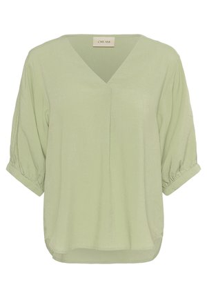 Blusa verde claro con escote en V, mangas abullonadas cortas y un corte relajado. La tela texturizada presenta finas estrías verticales que realzan su suavidad.