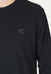 Svart långärmad T-shirt i mjukt, texturerat tyg, med en liten, glansig "FZ"-logotyp på vänster bröst.