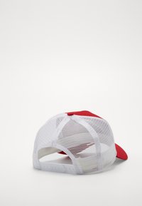 Casquette de baseball rouge avec une visière courbée, présentant un dos en maille blanche et une fermeture à pression réglable. Le design comprend des détails de couture.