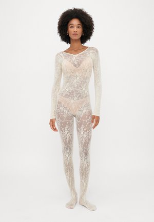 Nėriniuotas kūno kostiumas šviesiai baltais tonais, su ilgomis rankovėmis, gėlių raštais ir prigludusia forma. Pusiau skaidrus su lygiu paviršiumi.