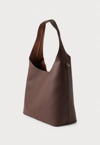 Brown leather tote bag with a slouchy design, wide shoulder strap, and subtle stitching details on the exterior. Smooth texture and minimalist style.