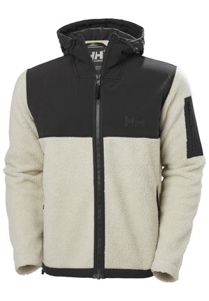 Chaqueta de forro polar con sección superior negra, sección inferior crema, cierre de cremallera, capucha y bolsillo lateral con cremallera. Presenta un tejido texturizado.