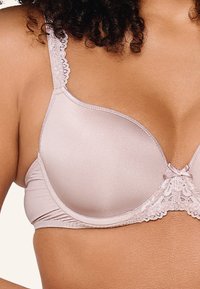 Reggiseno rosa chiaro con coppe lisce, simili alla seta, eleganti dettagli in pizzo sulle spalline e un fiocchetto al centro. Spalline regolabili e arricciature laterali.