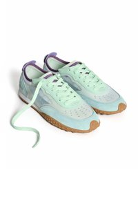 Zapatillas deportivas de color verde menta con parte superior de ante y malla, detalles en púrpura, suela de goma y perforaciones decorativas. Los cordones son de color verde menta.