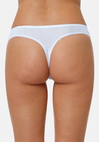 String blanc transparent avec une fine ceinture, en tissu doux, couvrance minimale et texture lisse, mettant en valeur un design simple.