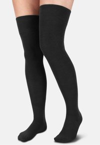 Schwarze, über dem Knie reichende Strümpfe aus einem weichen, dehnbaren Stoff mit einem gerippten oberem Bündchen, das eng am Bein sitzt.