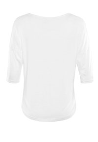 Witte, losvallende blouse met driekwartmouwen, ronde halslijn en zachte textuur. De zoom loopt rond aan de achterkant, zonder patronen of accenten.