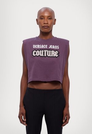 Purple cropped sleeveless top made from cotton with bold "Versace Jeans Couture" graphic in white and black lettering.