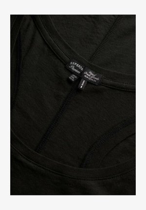 Sort bomuld tank top med rund halsudskæring, tynde stropper og syninger. Etiketter viser brand og plejeinformation. Glat tekstur.