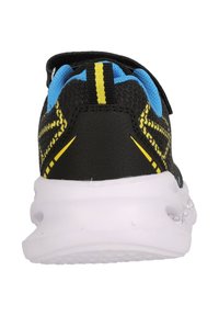 Svart träningsskor med en texturerad ovandel, gula och blå accenter samt en vit sula med luftkuddar för dämpning.