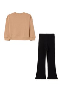 Tan sweatshirt met lange mouwen en geribbelde manchetten, gecombineerd met zwarte flared leggings. Beide items hebben een soepele textuur en eenvoudige ontwerpen.