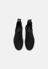 Stivaletti alla caviglia in suede nero con finitura liscia, pannelli elastici ai lati e linguette sul retro. Dotati di suola in gomma per una maggiore durata.