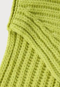 Strickstoff in leuchtendem Limettengrün, mit einer dicken Textur aus diagonalen Rippenmustern und weichen, flauschigen Fasern.