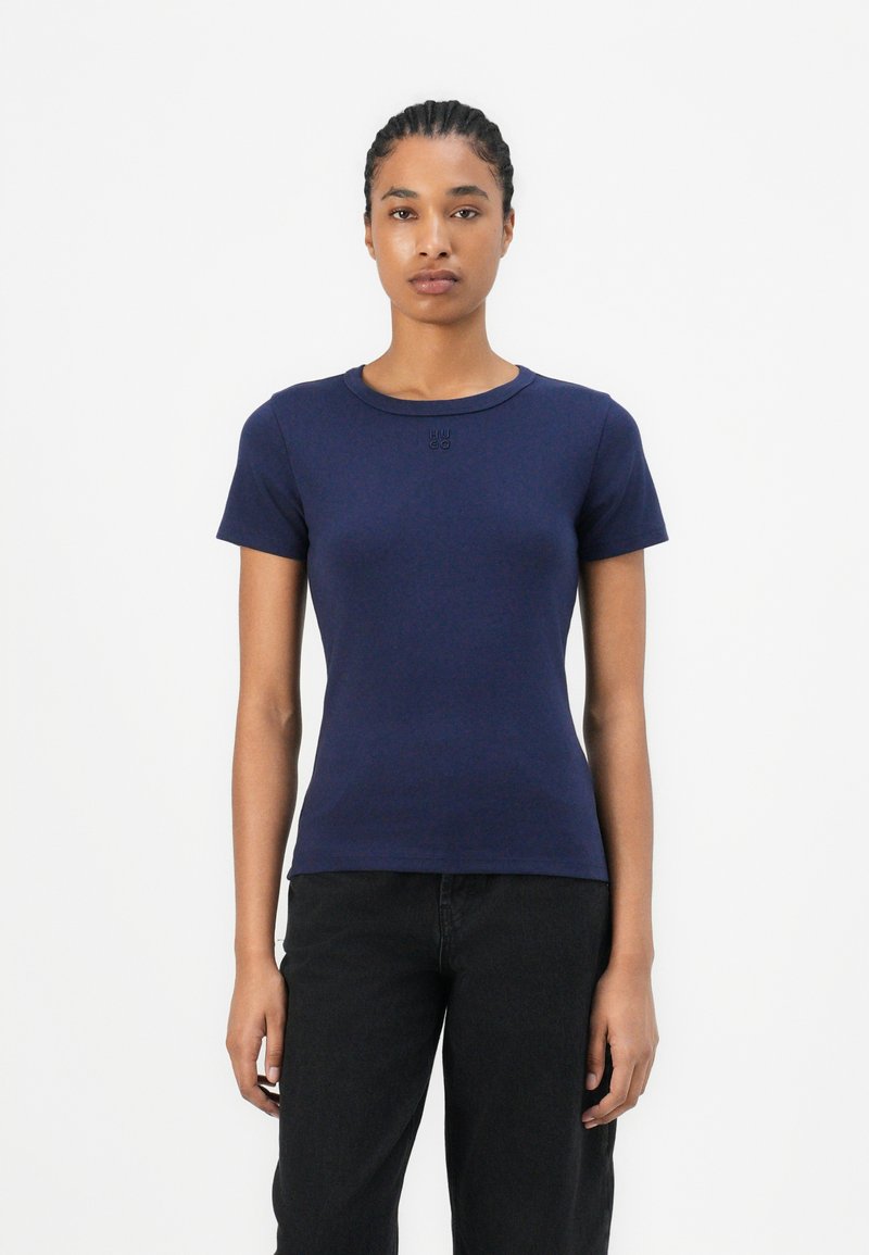 T-shirt ajusté bleu marine à manches courtes, col rond et avec un branding subtil sur la poitrine, fabriqué en coton doux.