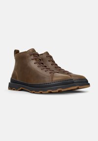Brown leather ankle boots with round toe, lace-up design, contrasting black rubber sole, and textured brown accents.