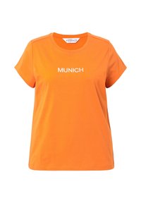 Oranges Baumwoll-T-Shirt mit kurzen Ärmeln, auf dem die Worte "MÜNCHEN" in weißer Stickerei über der Brust zu sehen sind, sowie einem runden Ausschnitt.