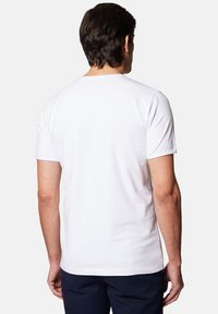 Biała bawełniana koszulka z prostym wzorem, krótkimi rękawami i okrągłym dekoltem, widziana od tyłu. Gładka faktura i dopasowany krój.