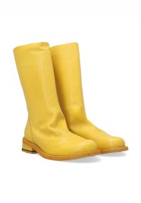 Gule læder støvler til knæene med en rund tå og en subtil slouch-design. Har en træsål med et lagdelt accent.