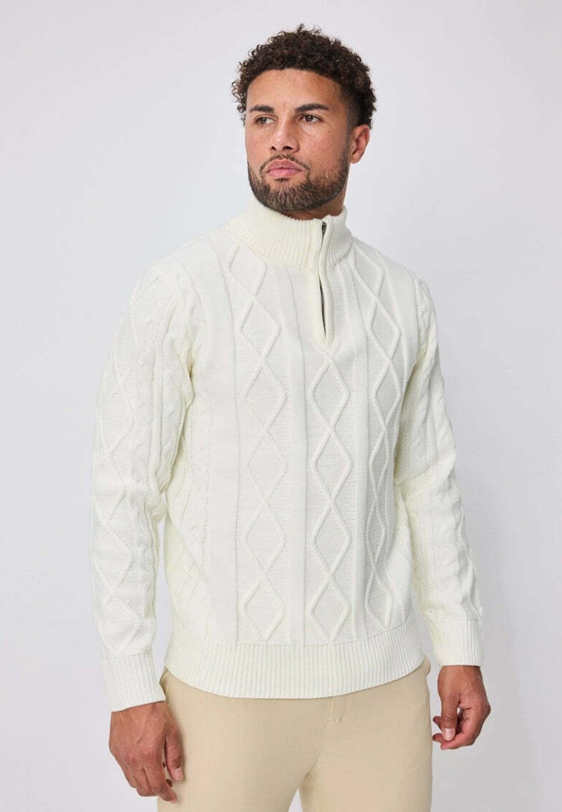 Pull en maille blanc cassé avec motifs en diamant texturés, doté d'un col montant et d'une fermeture éclair mi-longueur. Poignets et ourlet côtelés.