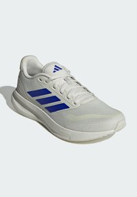 Zapatilla deportiva blanca con rayas azules, parte superior de malla, cuello acolchado y suela de goma con la marca "CLOUDfoam" en el costado.