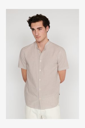 Lühikeste varrukatega nuppe kinnitatav särgike helespruunide ja valgete vertikaalsete triipudega, mandariinikaeluse ja beežide nuppudega. Puuvillane kangas.