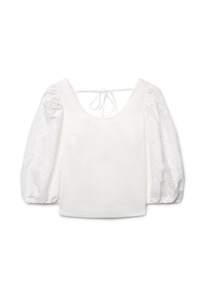 Camicia bianca con maniche a sbuffo in pizzo, scollatura rotonda e chiusura posteriore con laccio, realizzata in tessuto liscio e a motivi.