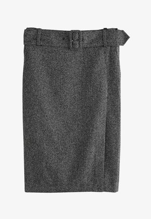 Kéz pihen egy derékban magasított, szürke halszálkamintás szoknya mellett, amely széles övvel és ezüst csattal van ellátva, fehér rövid ujjú felsővel párosítva.