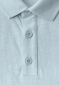 Světle modrá polo košile s texturovanou látkou, klasickým límcem, tříknoflíkovou légu a čtyřmi knoflíky s hladkým povrchem.