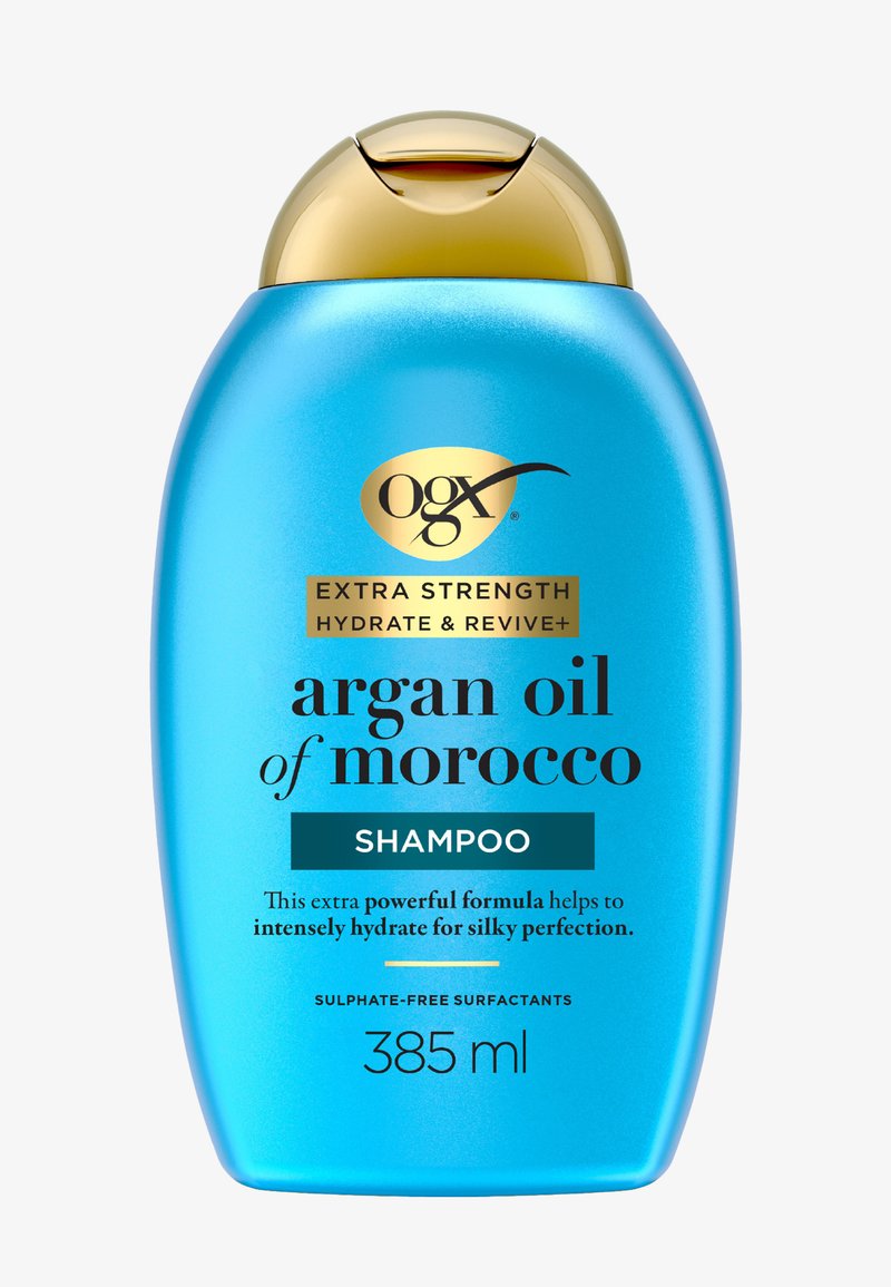 Flacon bleu de 385 ml de shampooing OGX à l'huile d'argan du Maroc avec bouchon doré, formule extra hydratante et revitalisante, tensioactifs sans sulfate.