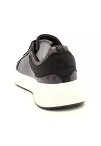 Grå och svart sneakers med tjock vit sula, synlig varumärkeslogotyp på hälen och vadderad krage, visad från en bakre vinkel.