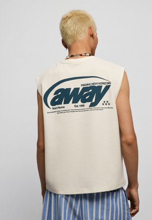 Osoba s krátkymi blond vlasmi, ktorá nosí bezrukávový béžový top s tučným textom "away" a modro-biele pruhované nohavice, otočená chrbtom.