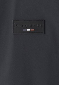Black textile featuring a rectangular leather label with embossed "bugatti" text and three horizontal stripes in blue, white, and brown.
