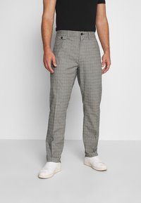 Pantalones de vestir con patrón de espiga gris, de corte recto, que cuentan con bolsillos laterales, cierre de botón y una textura suave.