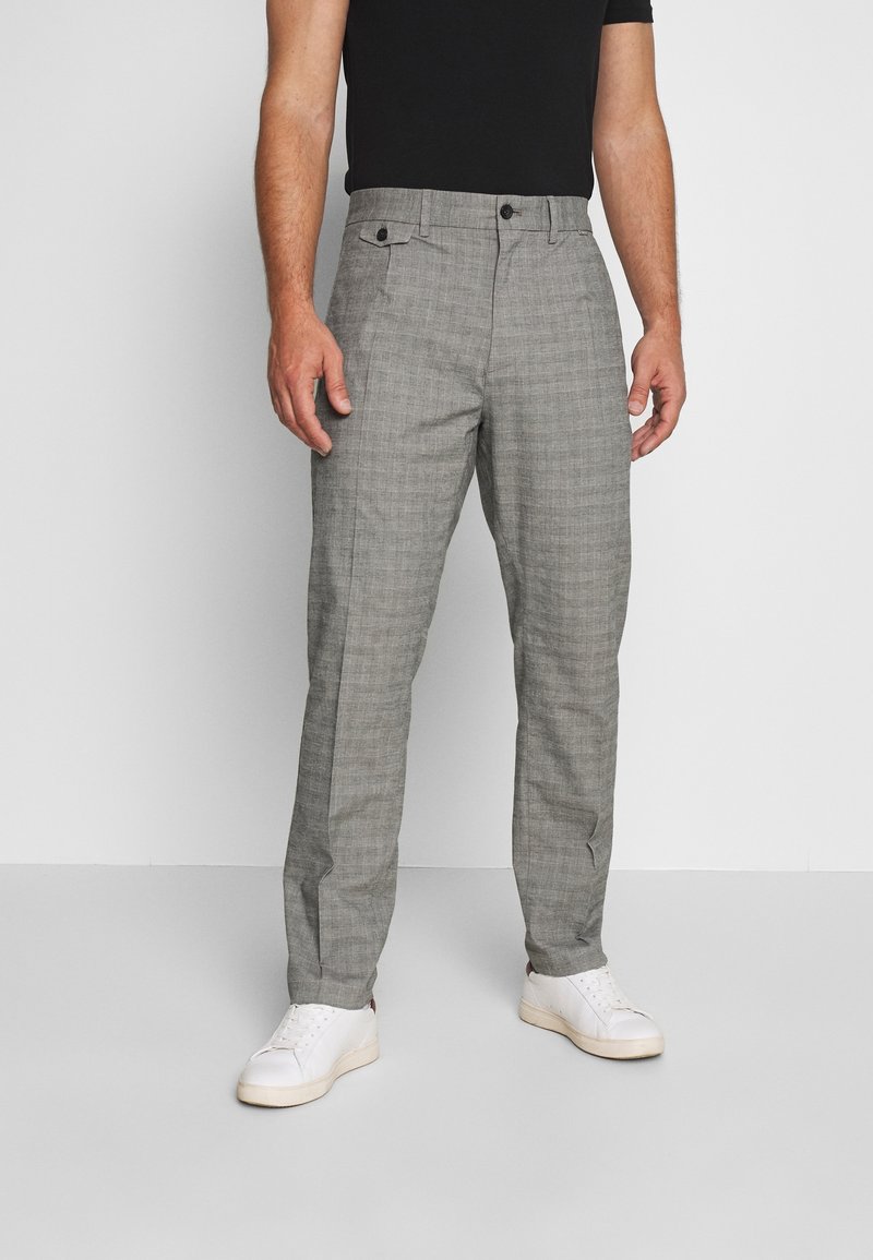 Pantalones de vestir con patrón de espiga gris, de corte recto, que cuentan con bolsillos laterales, cierre de botón y una textura suave.