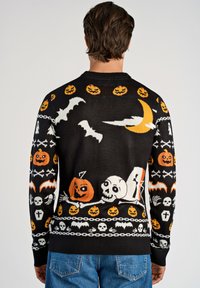 Czarny sweter z wzorami w Halloween w kolorach pomarańczowym, białym i żółtym. Na plecach znajdują się nietoperze, dynie, duchy i czaszki.