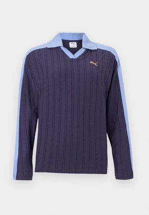 Navy long-sleeve knit polo with vertical ribbing, light blue collar and shoulder stripes, and small gold Puma logo on the chest.