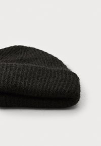 Berretto in maglia nera con risvolto, realizzato in filato morbido e texturizzato. Presenta un motivo a coste e un aspetto caldo e morbido.