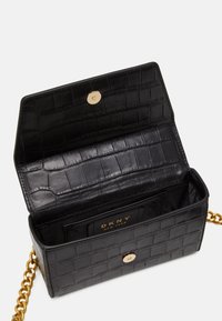 Borsa in pelle nera effetto coccodrillo con chiusura a scatto dorata e tracolla a catena. Interno dotato di taschino per carte e fodera texturizzata.