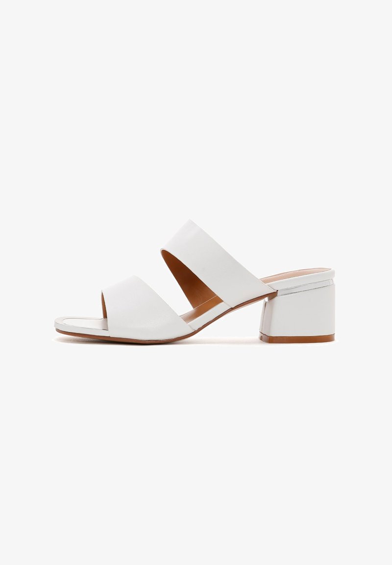 Sandales à talons blocs en cuir blanc avec deux larges lanières et un design à bout ouvert. Caractéristiques d'un talon carré et d'une texture lisse.