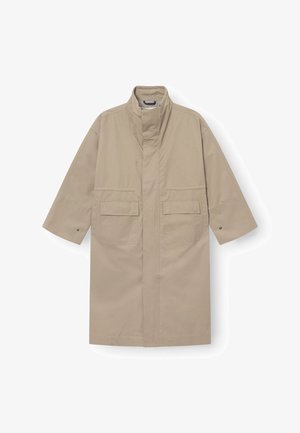 Beiger langer Mantel mit hohem Kragen, vorderen Klappentaschen, weiten Ärmeln mit Druckknöpfen und verdecktem vorderem Verschluss.