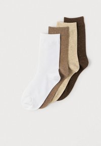 Sæt af fire sokker: hvid, lysebrun, beige med en subtil tekstur og mørkebrun med små prikker. Alle i midt-længde til læggen, lavet af blødt stof.