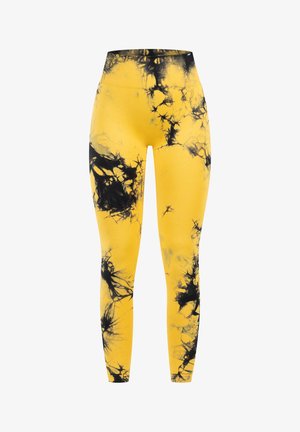 Żółte legginsy z czarnym wzorem tie-dye, z wysokim stanem i gładką, elastyczną teksturą, idealne do aktywności fizycznej.