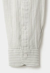 Poignet de chemise rayée verticalement beige clair et blanc avec deux boutons et un bord arrondi sur fond blanc.