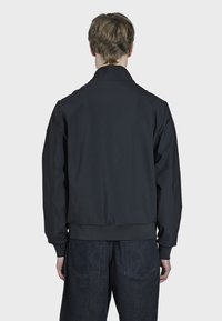 Veste bomber noire, légère, avec un ourlet et des poignets côtelés. Dotée d'un design simple et d'une texture lisse, vue de dos.
